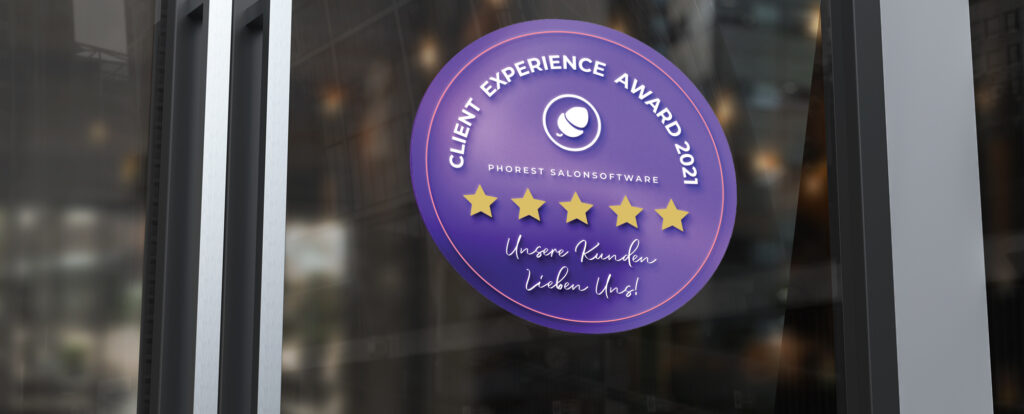 Ein runder, lila Aufkleber, auf dem 5 Sterne zu sehen sind und auf dem geschrieben ist "Client Experience Award, Phorest Salon Software, Unsere Kunden lieben uns!" klebt auf einer Scheibe