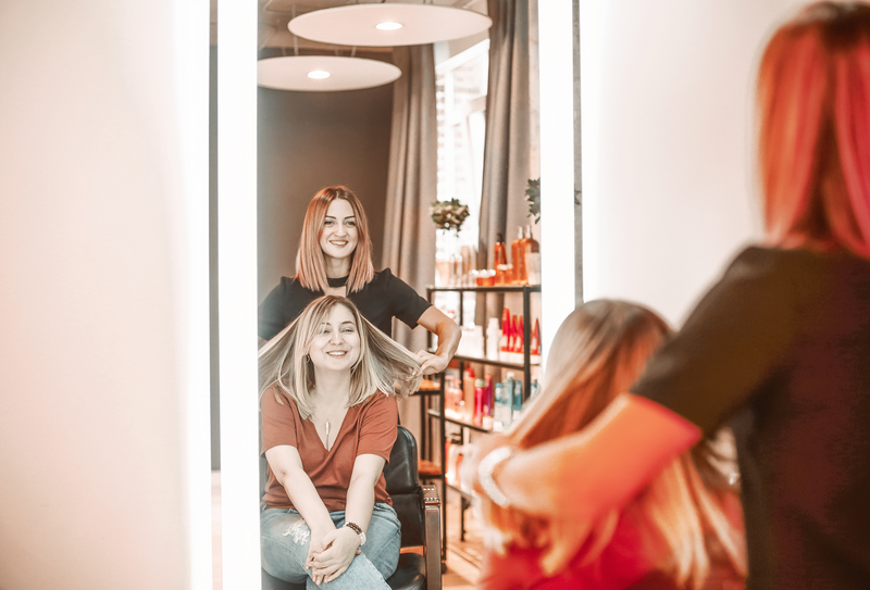 Friseurin präsentiert Kundin die fertigen Haare. Kundenbewertungen für tolle Termine.